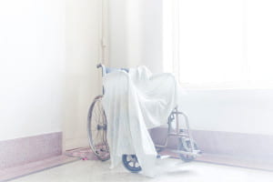 Bright room with wheelchair covered in white cloth