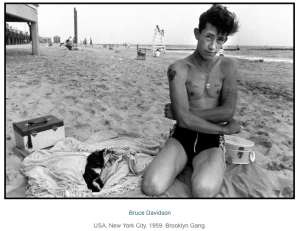 Young man at the beach sitting in the sand