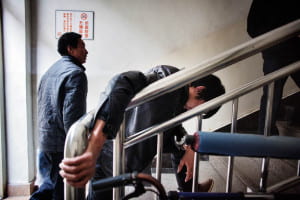 man leaning heavily on stairwell banister