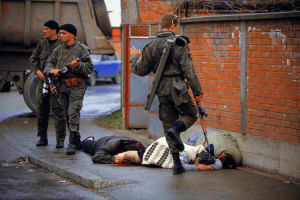 Soldier kicking people laying on the street