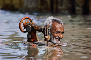 man with sewing machine in neck high water