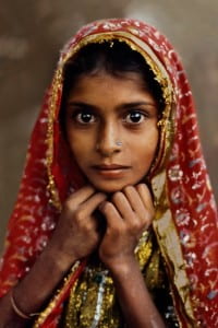 Young girl with red headscarf staring intently 