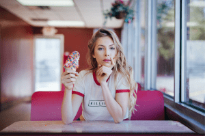 Young woman with long blonde hair holding ice cream cone