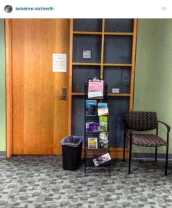 Office door with pamphlets and chair in front of it.