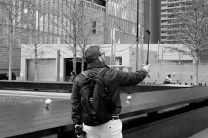 man with bookbag taking selfie 