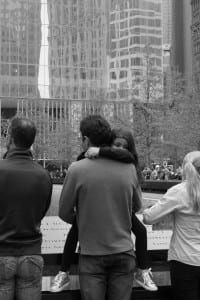 man holding child in front of memorial