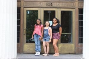 three girls in front of building