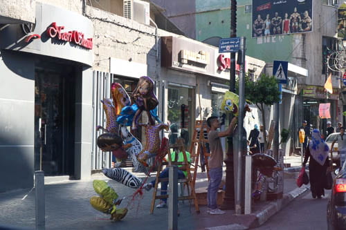 man on the street with balloons