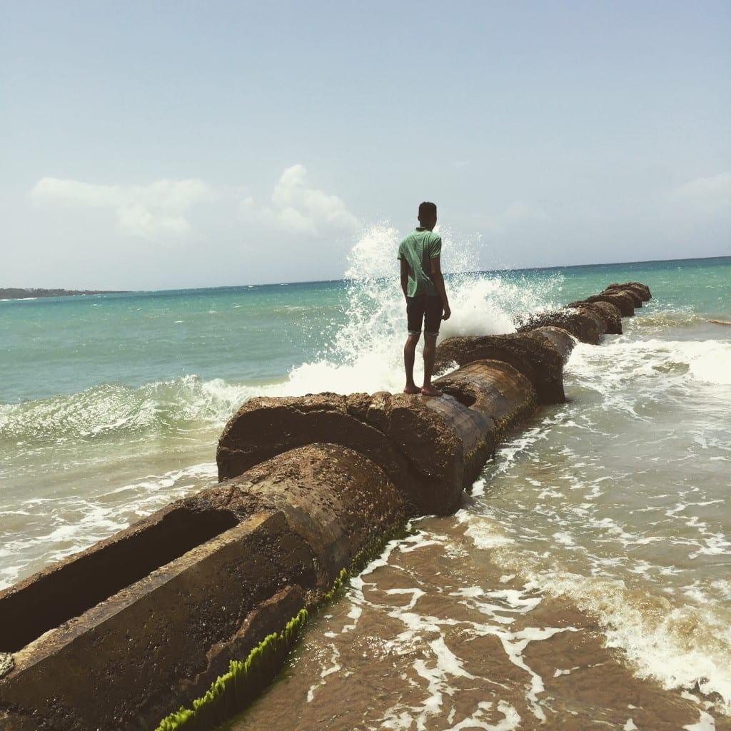 the author standing on old pipe leading into the ocean