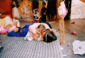 children lying on a mattress on the ground