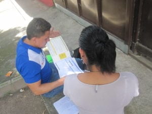 man showing brochure to a woman