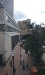 city plaza with large building and marchers in the distance