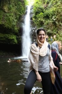 Iranian woman in front of waterfall