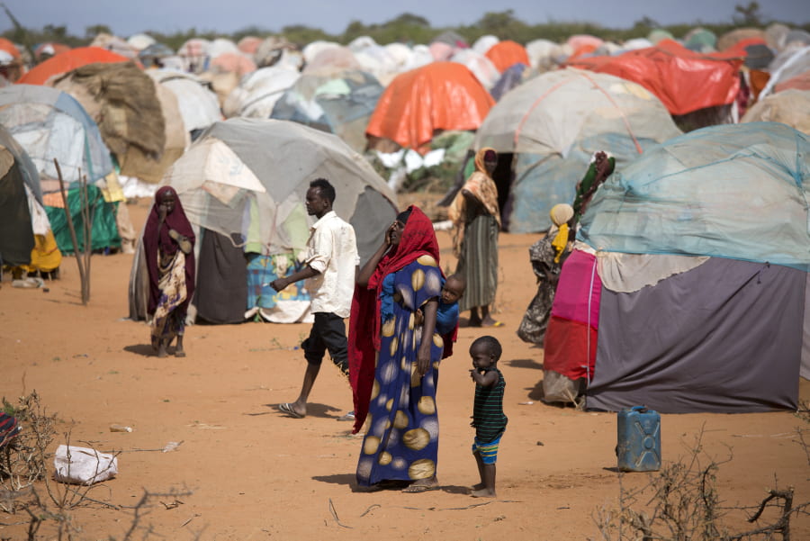 A women and her child in Somalia surrounded by hundreds of tents