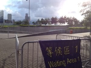 Outdoor pavilion with metal barriers with sign stating "waiting area".