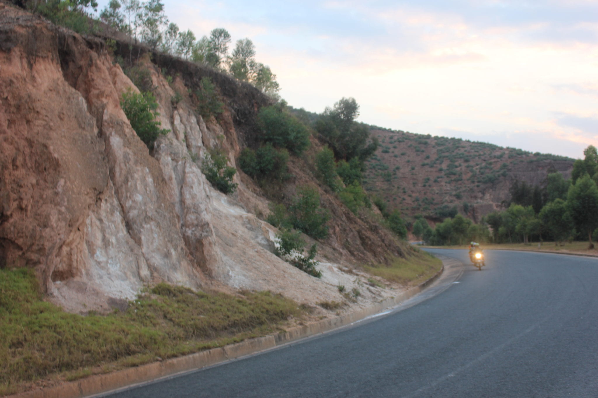 Motorcycle driver on the road amongst the hills. 