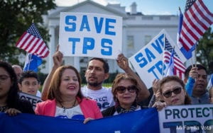 protesters waving "save TPS" signs and American flags