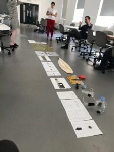 people in a room with papers and materials on the floor