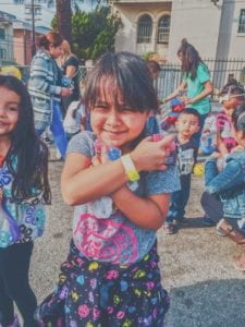 immigrant girl standing near children and adults