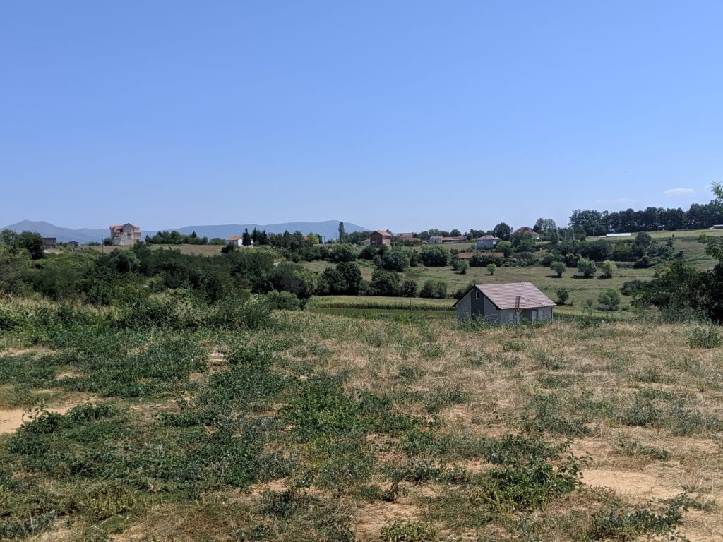 a few houses scattered in grassy area