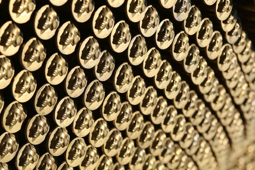 rows of gold coins imprinted with relief of woman's face