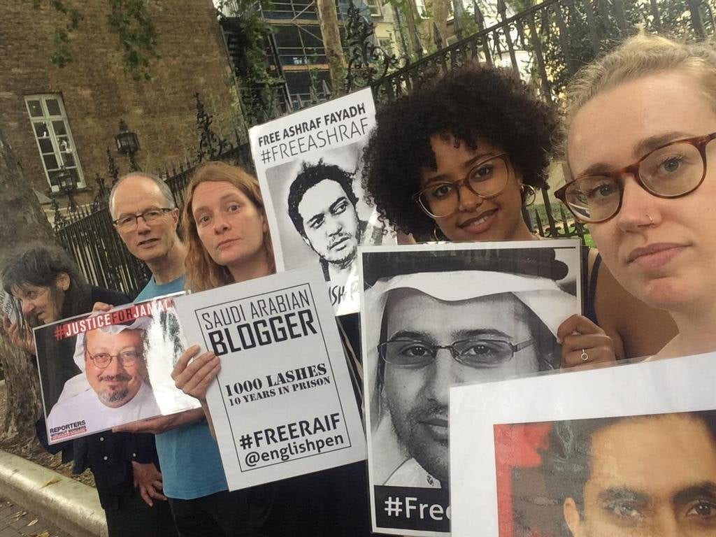 the author and others holding protest flyers outside a gate