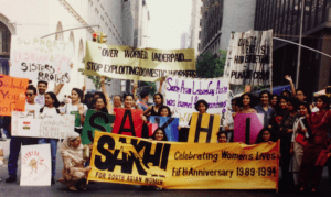 An image from a Sakhi organized march, where marchers are holding charts highlighting a range of different dimensions about women's rights: domestic workers' issues and queer rights. 