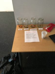 Voting for the Name of Neighborhood, featuring jars with names in front of them and a bag of candy to vote with.