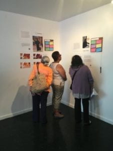 Three people looking at the exhibit in a corner.